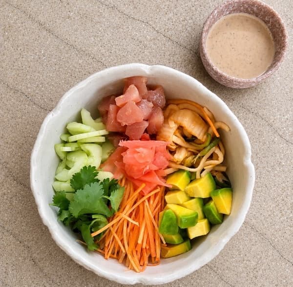 Tuna poke  — Fresh tuna served over Japanese rice with avocado, orange, cucumber, carrot, cilantro, and marinated