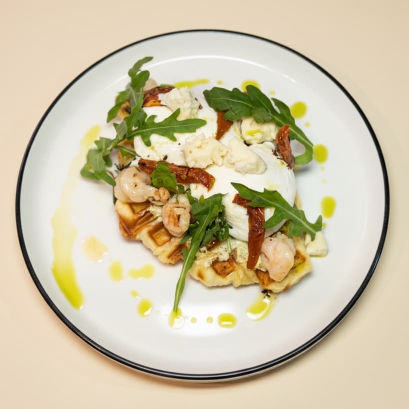 Pesto shrimps croffle — Croissant waffle, pesto cream cheese, homemade sun dried tomato, shrimps, arugula, green oil, sprink