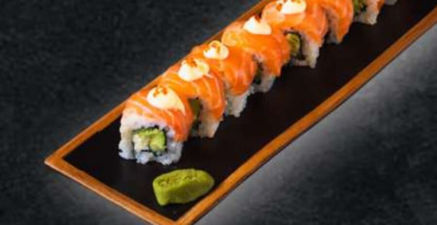 Philadelphia Roll — Rice, nori, sesame seeds, cheese, avocado, cucumber, salmon on top, mayonnaise, tobikko