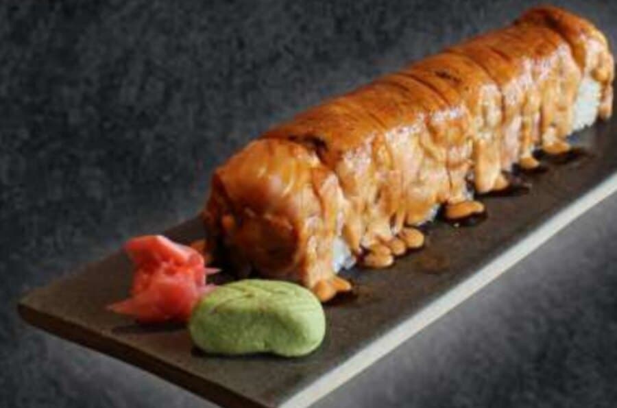 Salmon Aburi — Rice, nori, cheese, avocado, cucumber, sauteed salmon, crunchy, salmon on top, teriyaki sauce, menta